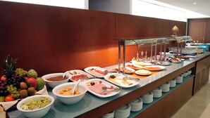 Un buffet proposant une variété de plats et une présentation de fruits.