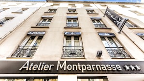 A building with the sign "Atelier Montparnasse" and balconies with wrought iron railings. - Atelier Montparnasse (Paris)