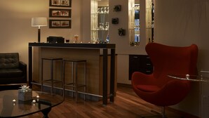 Eine moderne Küche mit Barbereich, einem roten Stuhl und einem Glastisch mit Kerzen.