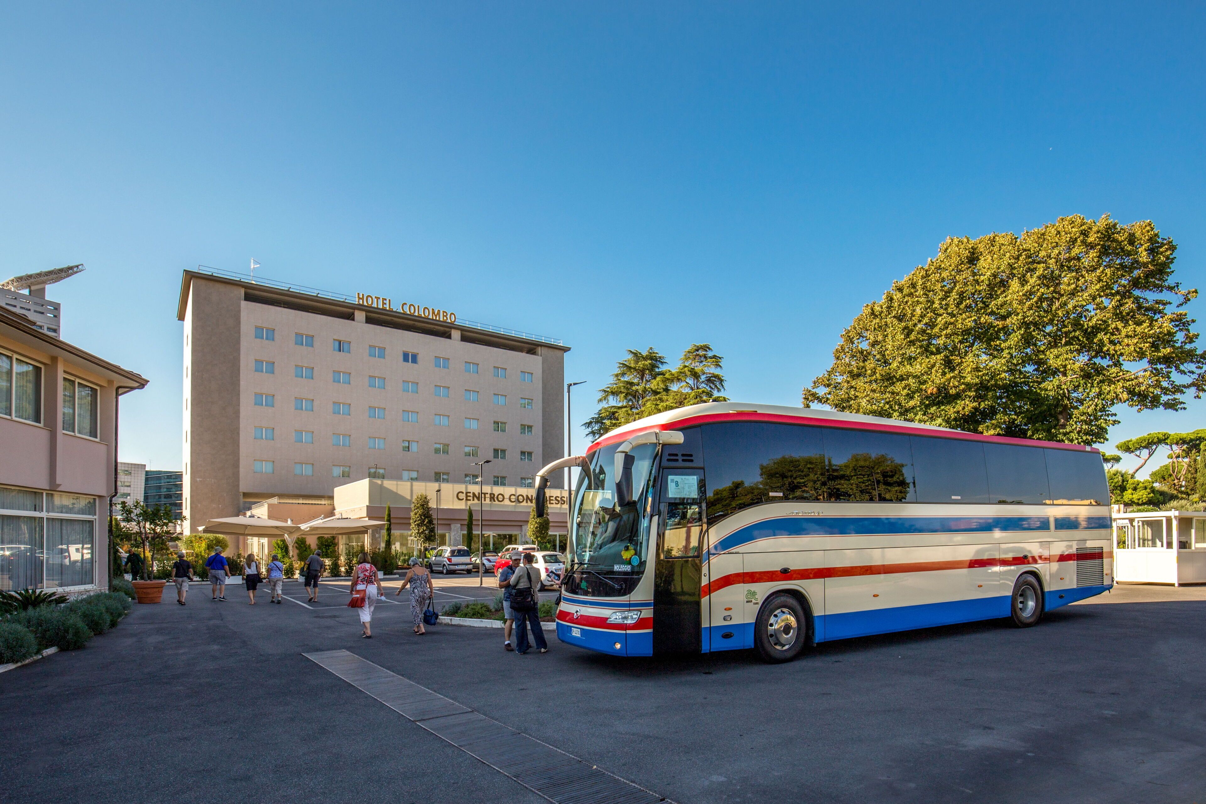 A large bus parked in front of a hotel with a sign reading "HOTEL COLORADO".