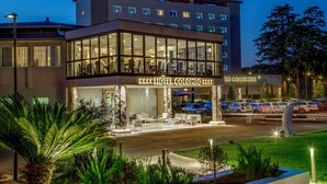 A hotel with a modern design, featuring a glass facade, a rooftop terrace, and a well-lit entrance. - Hotel Cristoforo Colombo (Rome)