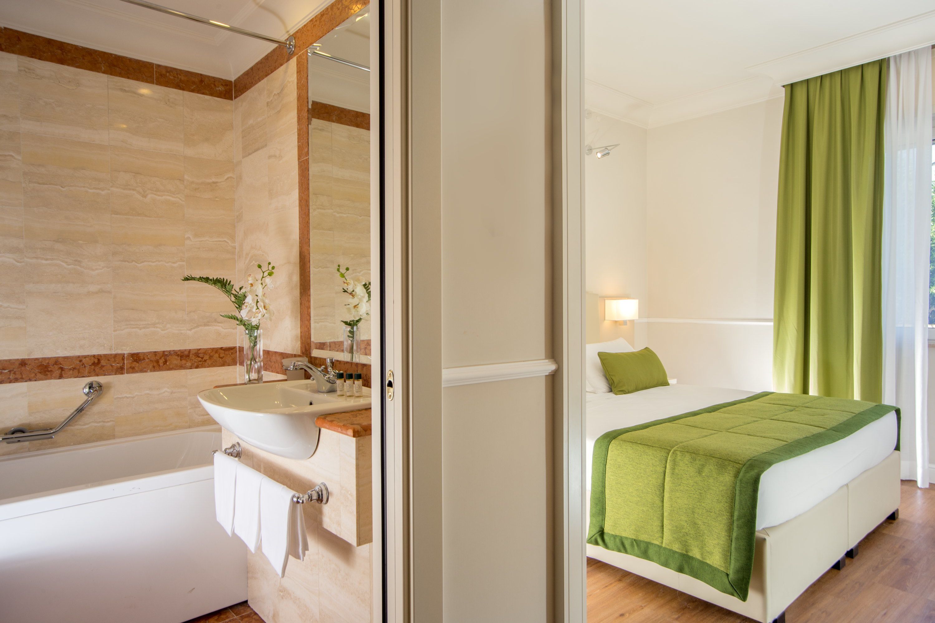 A modern bathroom with a bathtub, sink, and mirror.