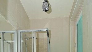 Une salle de bain moderne avec une douche à parois de verre, un lavabo blanc et des toilettes.