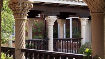 Un espacio al aire libre cubierto con columnas de piedra y barandilla de madera.
