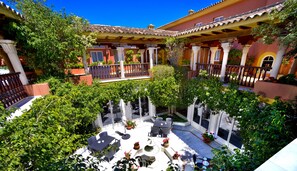 A courtyard with outdoor seating, a fountain, and lush greenery. - Hotel Alborán Algeciras (Algeciras)