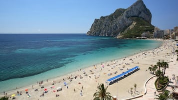 Plage, sable blanc, chaises longues, parasols