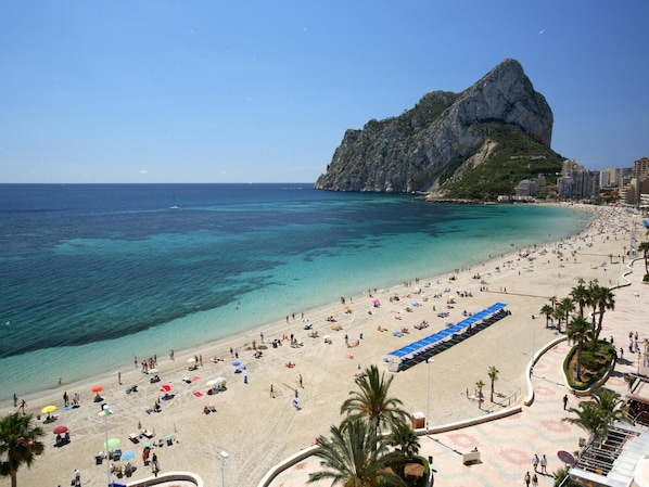 On the beach, white sand, sun loungers, beach umbrellas