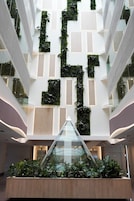 A modern interior with a central atrium, glass railings, and a geometric wall design.