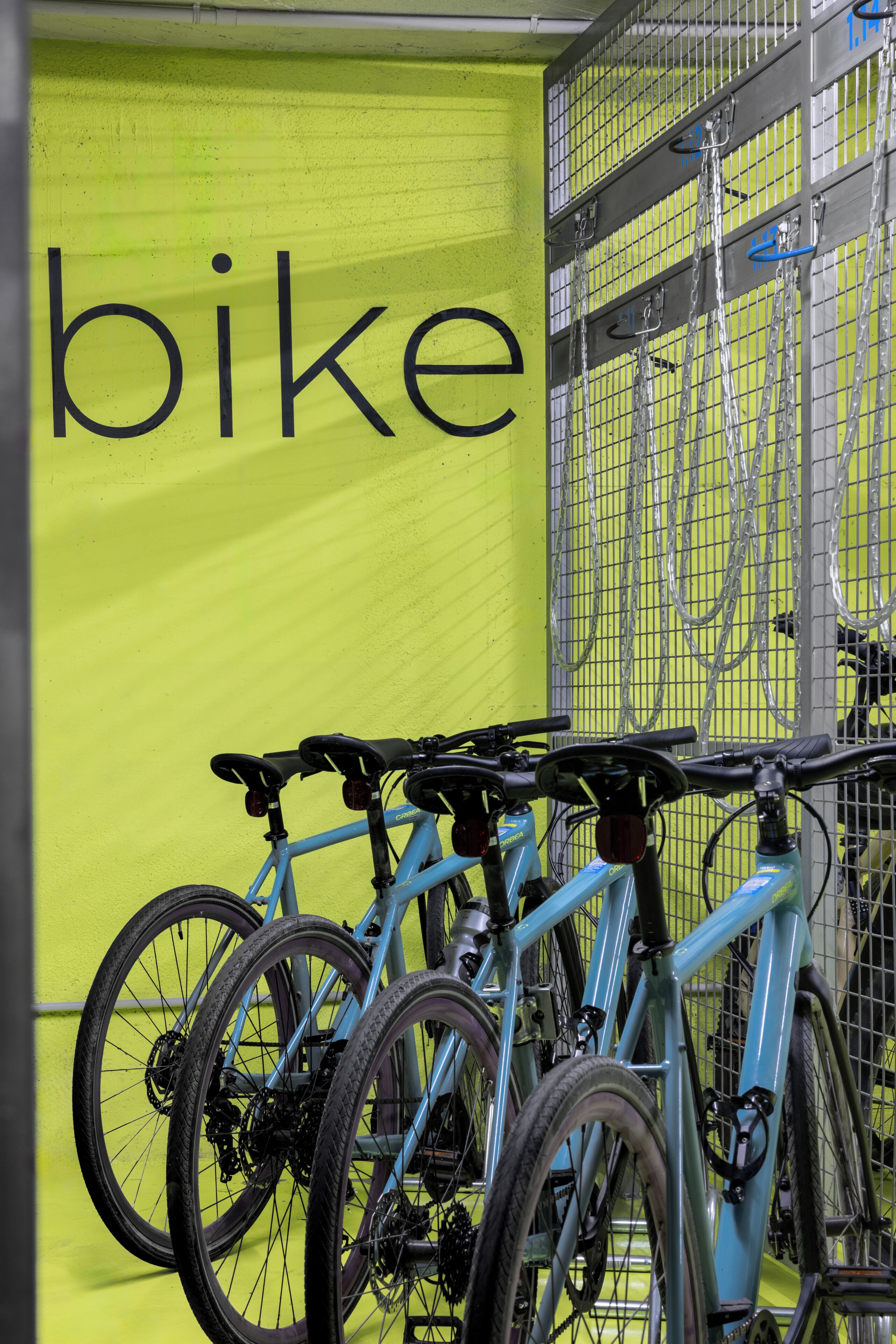 Bicicletas estacionadas contra una pared con un cartel que dice 'bike'.