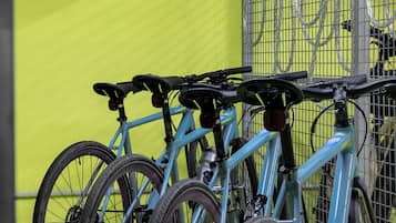 Bicicletas estacionadas contra una pared con un cartel que dice 'bike'.