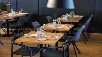 Un restaurante con varias mesas dispuestas para comer, cada una con sillas y ajuares de mesa.