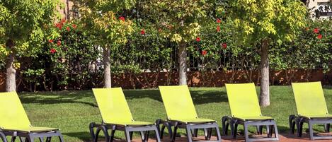 Zona junto a la piscina con sillones de descanso y una piscina de ladrillo.