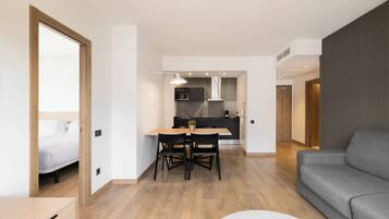 Eine moderne Wohnung mit Essbereich, Küche und einem grauen Sofa.