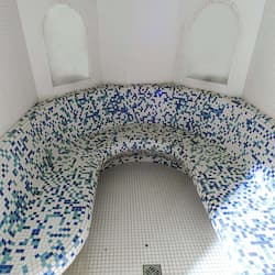 Relax in a spacious room with a curved bathtub and stylish tilework.