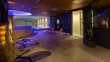 Un área de spa con un jacuzzi, asientos y una silla de masaje fijada a la pared.