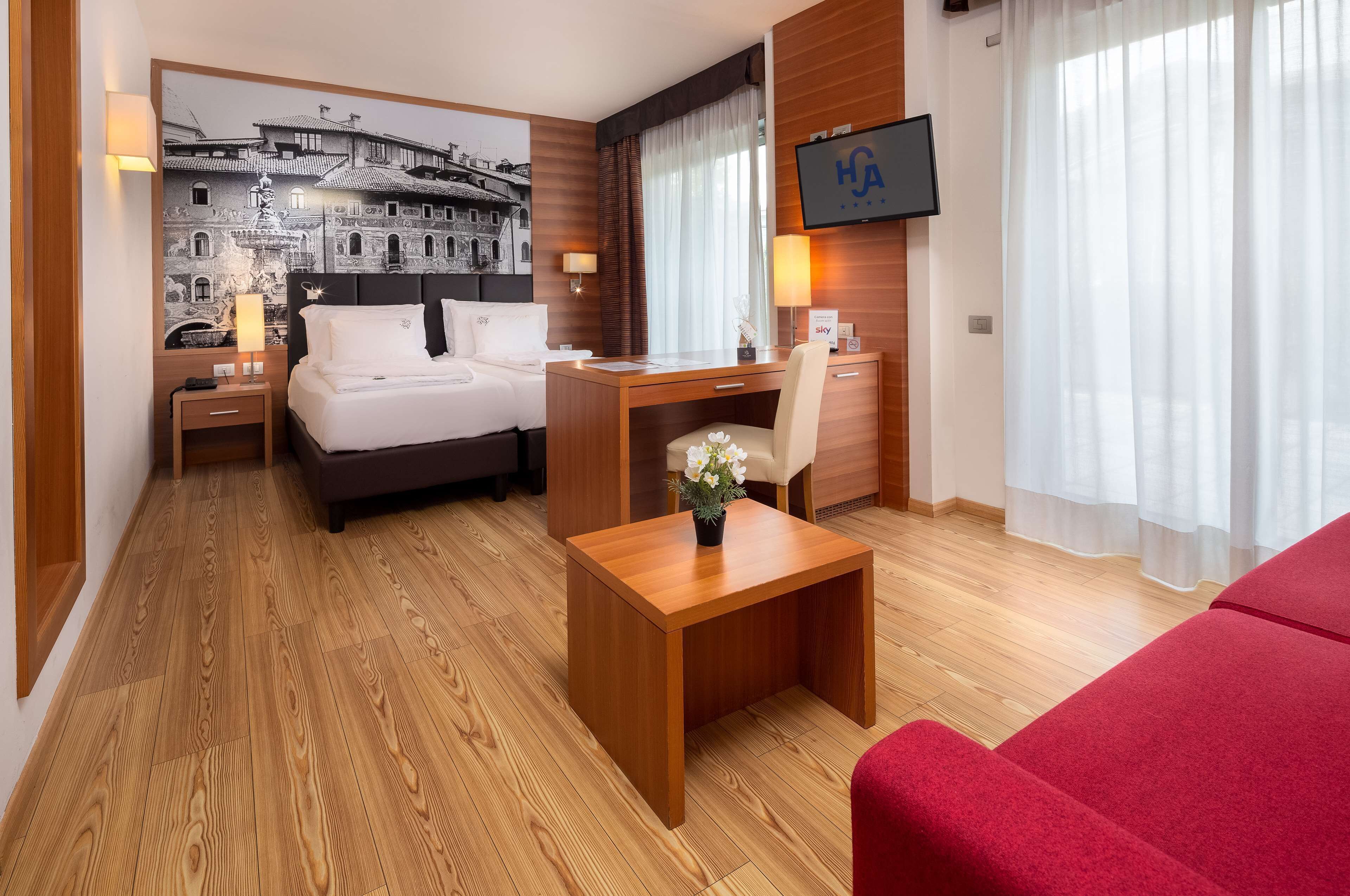 Une chambre d’hôtel avec un lit, un bureau et une télévision.