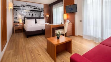 Une chambre d’hôtel avec un lit, un bureau et une télévision.
