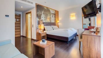 Une chambre d’hôtel moderne équipée d’un grand lit, d’un bureau, d’un canapé et d’une télévision.