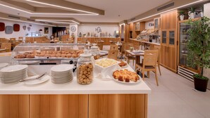 A breakfast buffet area with various pastries, cookies, and bread. - Best Western Hotel Adige (Trento)