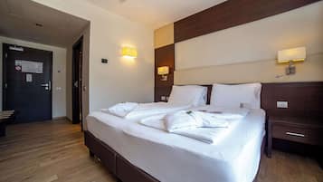 Ein Hotelzimmer mit einem großen Bett, Nachttischen und Wandlampen.