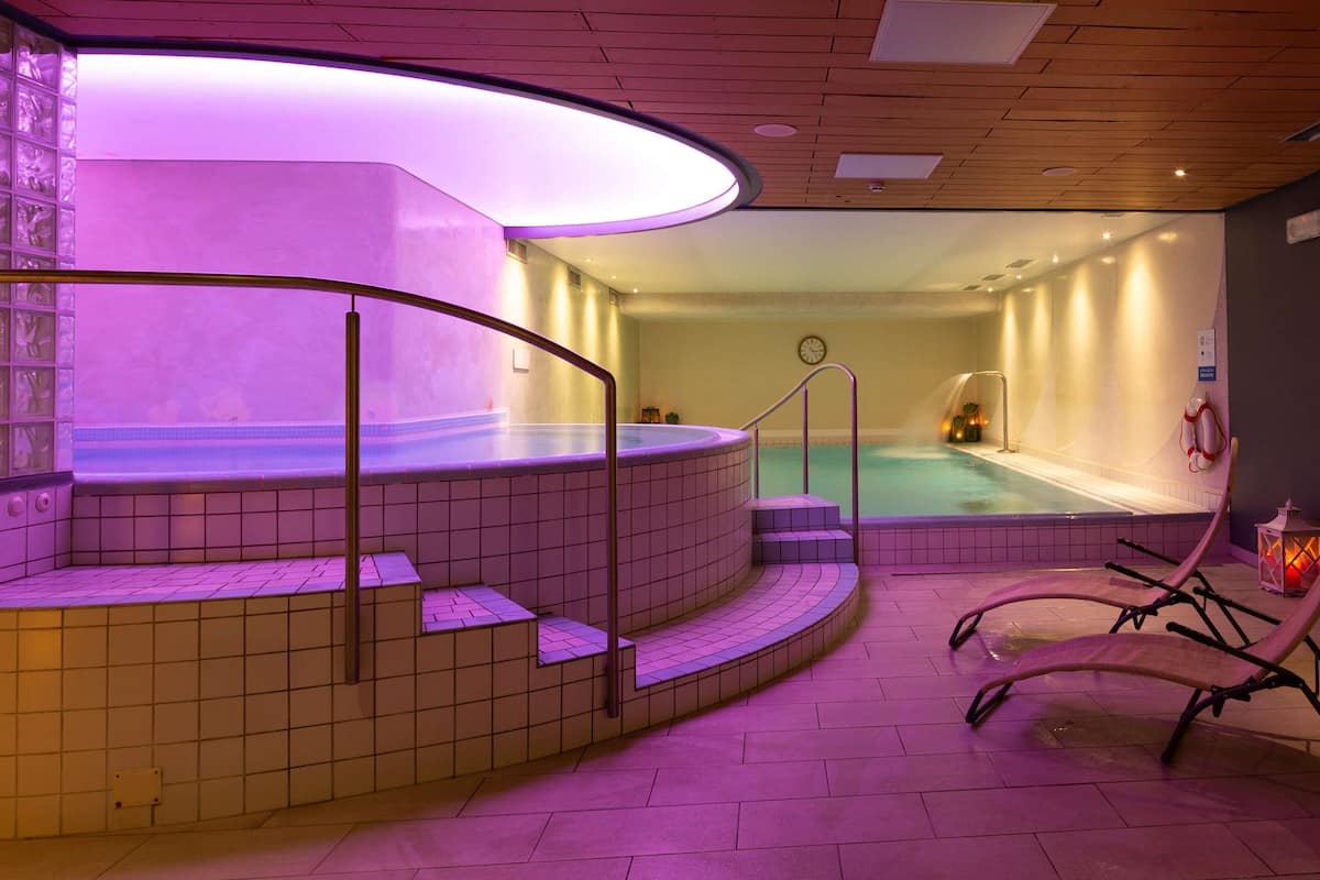 A spa area with a hot tub, seating, and ambient lighting.