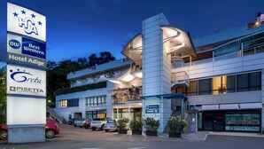 A hotel with multiple floors, a modern design, and a signboard with various hotel names. - Best Western Hotel Adige (Trento)
