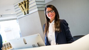 A person seated at a desk with a laptop, a bookshelf with books, and a security camera on the ceiling. - Windsor Hotel And Tower (Córdoba)