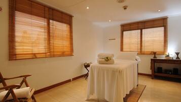 Relax in a serene space with a large bed, wooden blinds, and a side table.