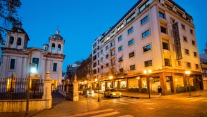 A hotel with a classic architectural style, featuring a prominent entrance with a gated driveway and a well-lit street view. - Windsor Hotel And Tower (Córdoba)