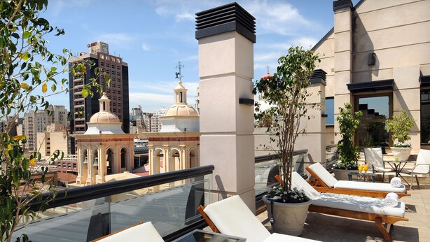 A rooftop terrace with lounge chairs, a glass table, and potted plants. - Windsor Hotel And Tower (Córdoba)