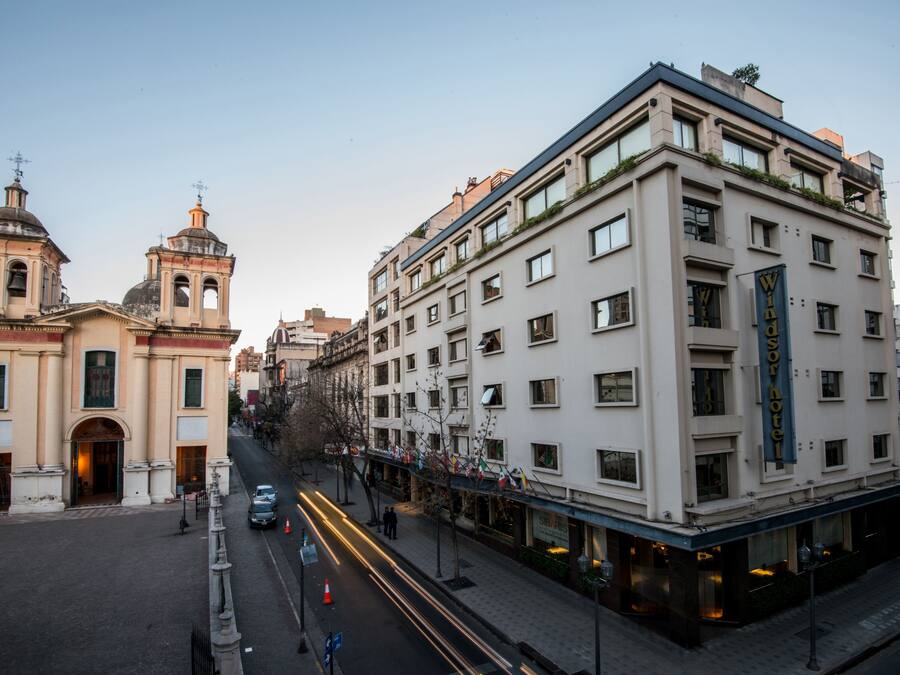 A hotel with a modern facade, a bell tower, and a sign indicating it is a hotel.