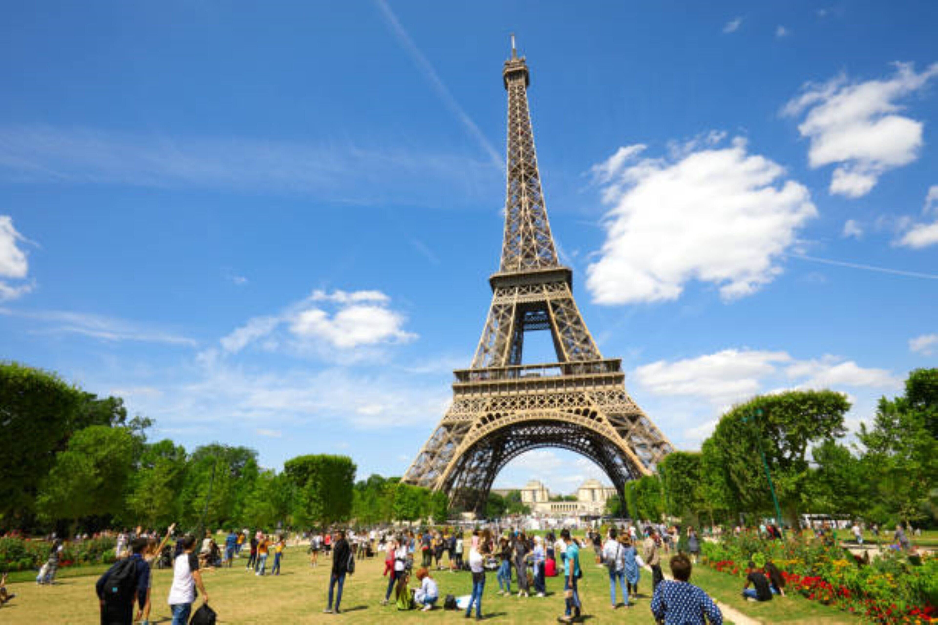 The Eiffel Tower in a park with visitors.