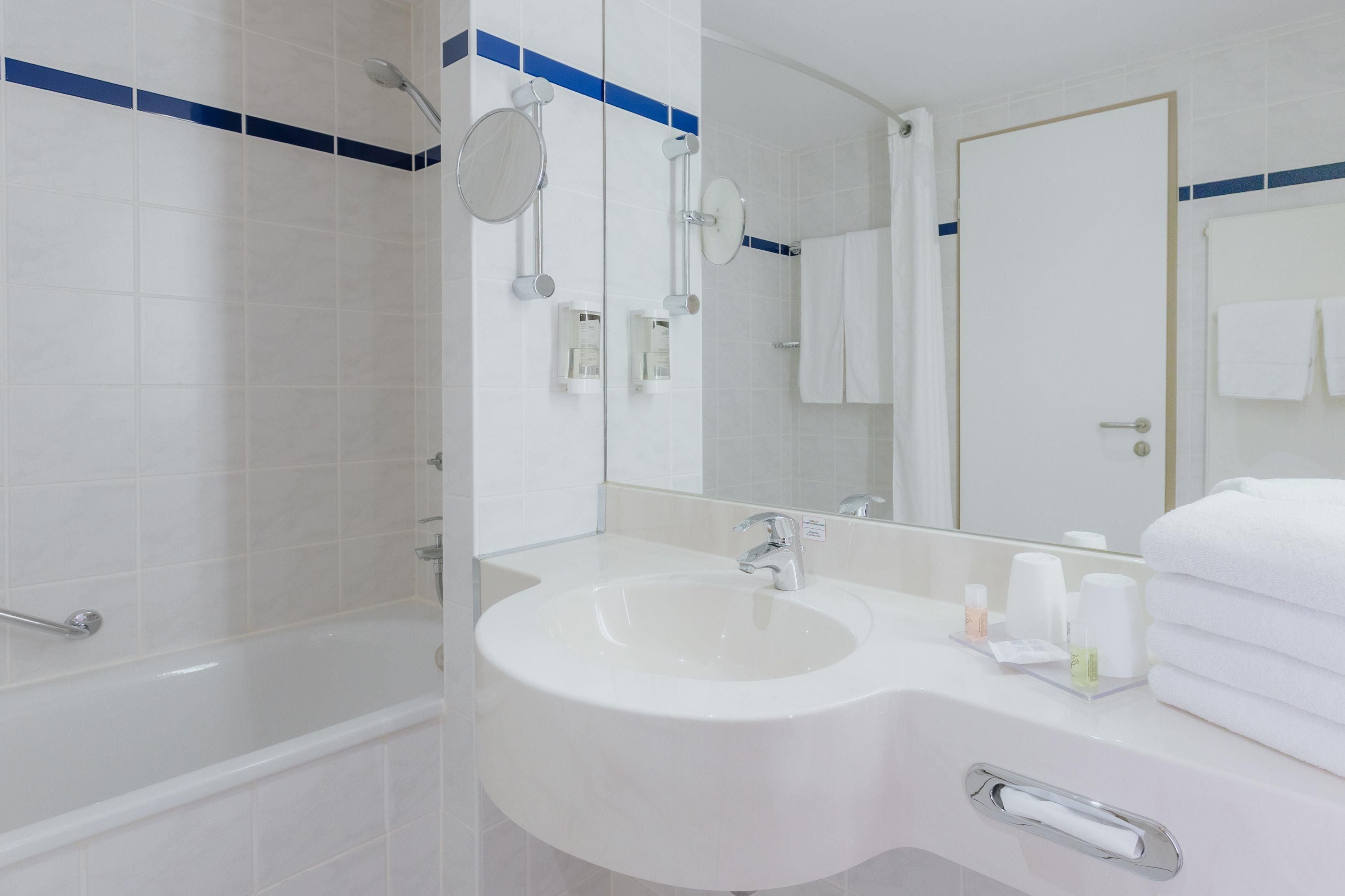 Ein modernes Badezimmer mit Badewanne, Waschbecken und einem großen Spiegel.