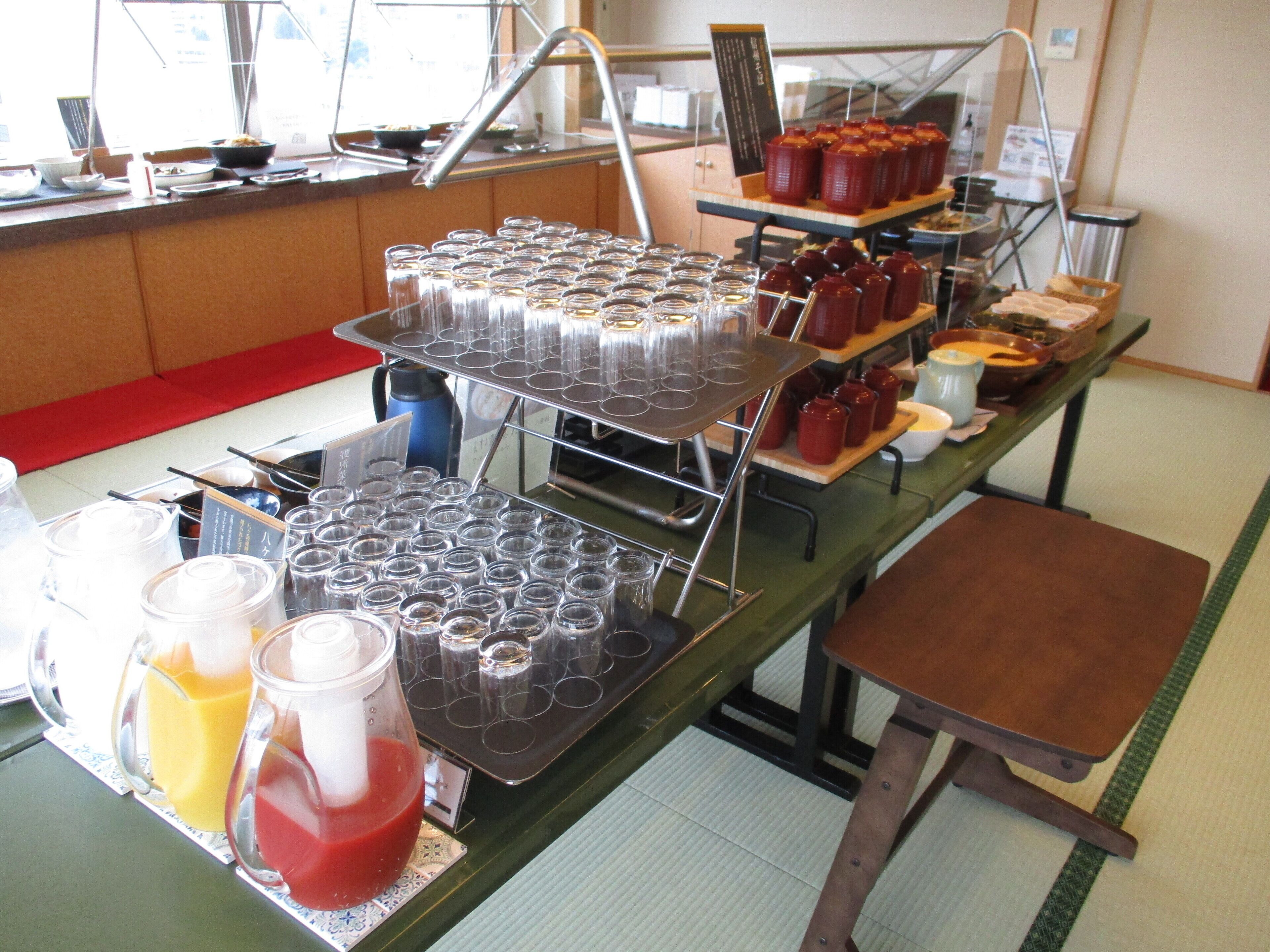 Een buffetopstelling met verschillende drankdispensers, een verscheidenheid aan gerechten en een zithoek.