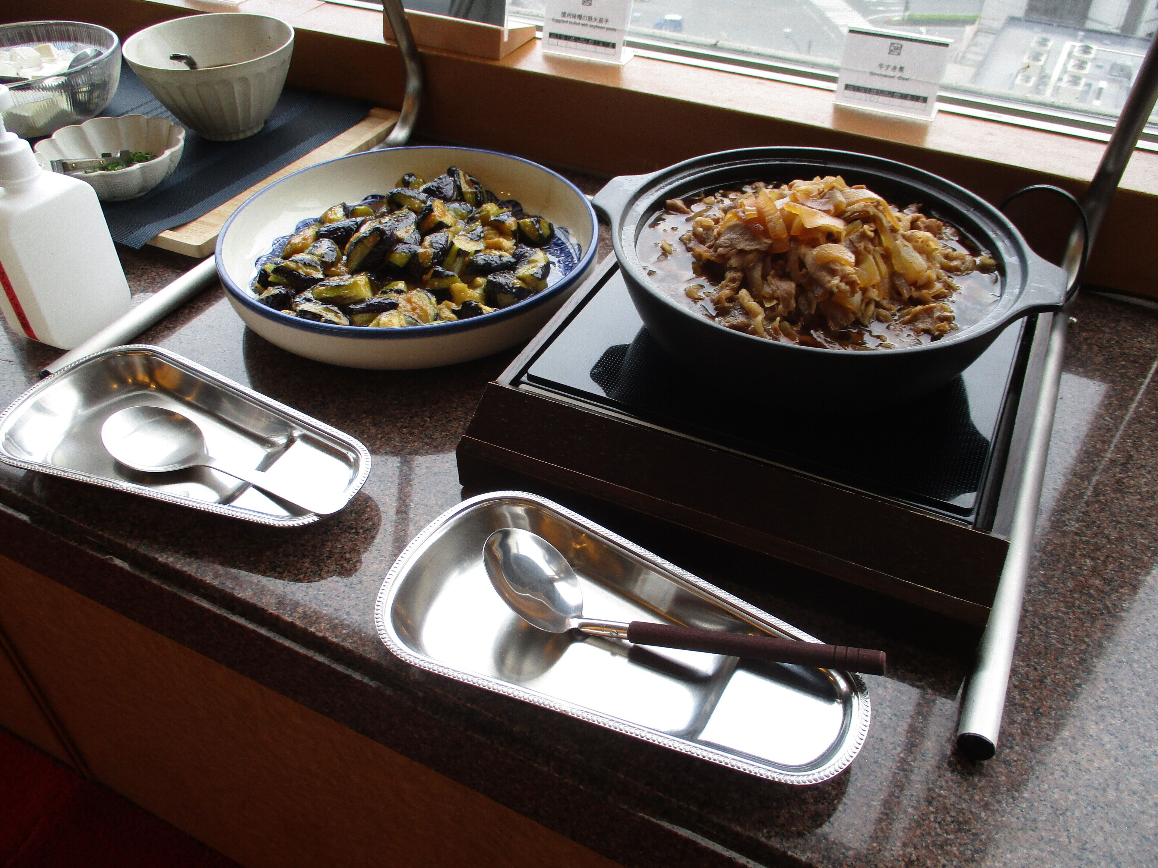 Un comptoir de cuisine avec différents plats, une bouteille et une cuillère.