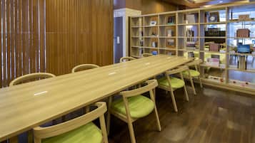A wooden table with chairs, a bookshelf, and a wooden wall.