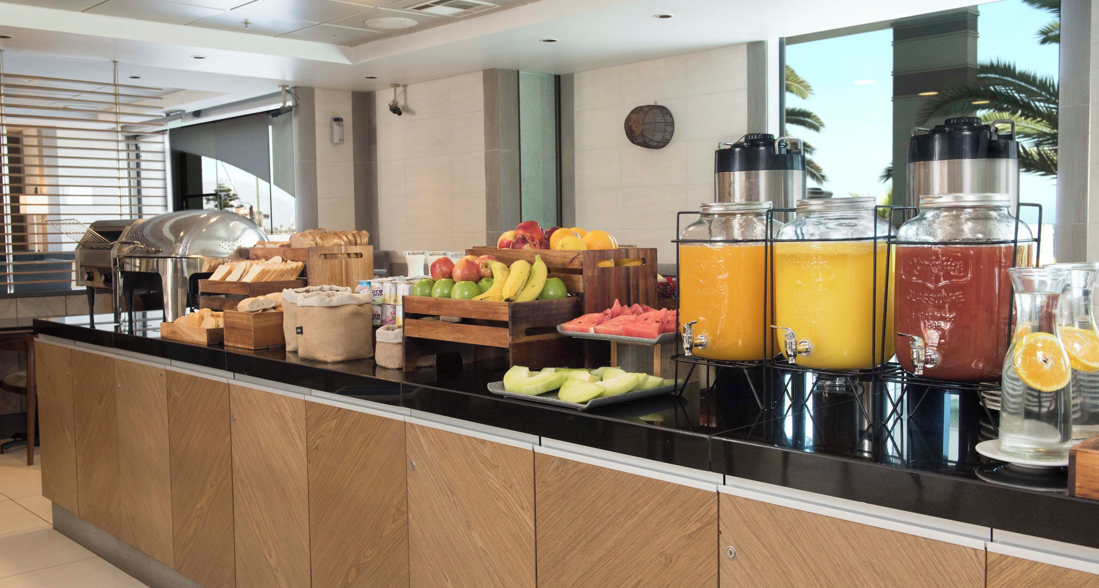 Ein reichhaltiges Frühstücksbuffet mit verschiedenen Früchten, Brot und Getränken.