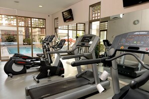 A gym with treadmills, ellipticals, and a pool area visible through large windows. - Holiday Inn Express Antofagasta by IHG (Antofagasta)