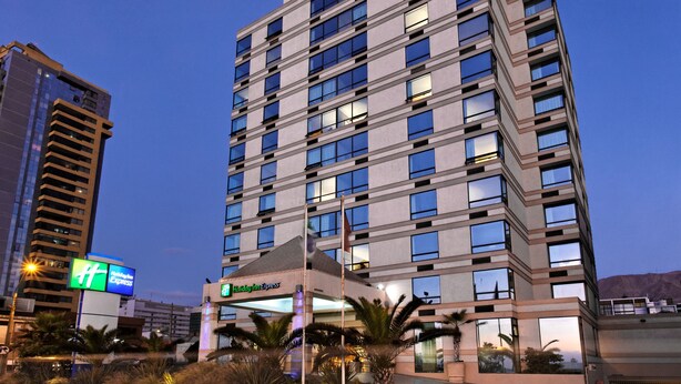 Un hôtel à plusieurs étages au design moderne, reconnaissable à son grand panneau « Holiday Inn Express ».