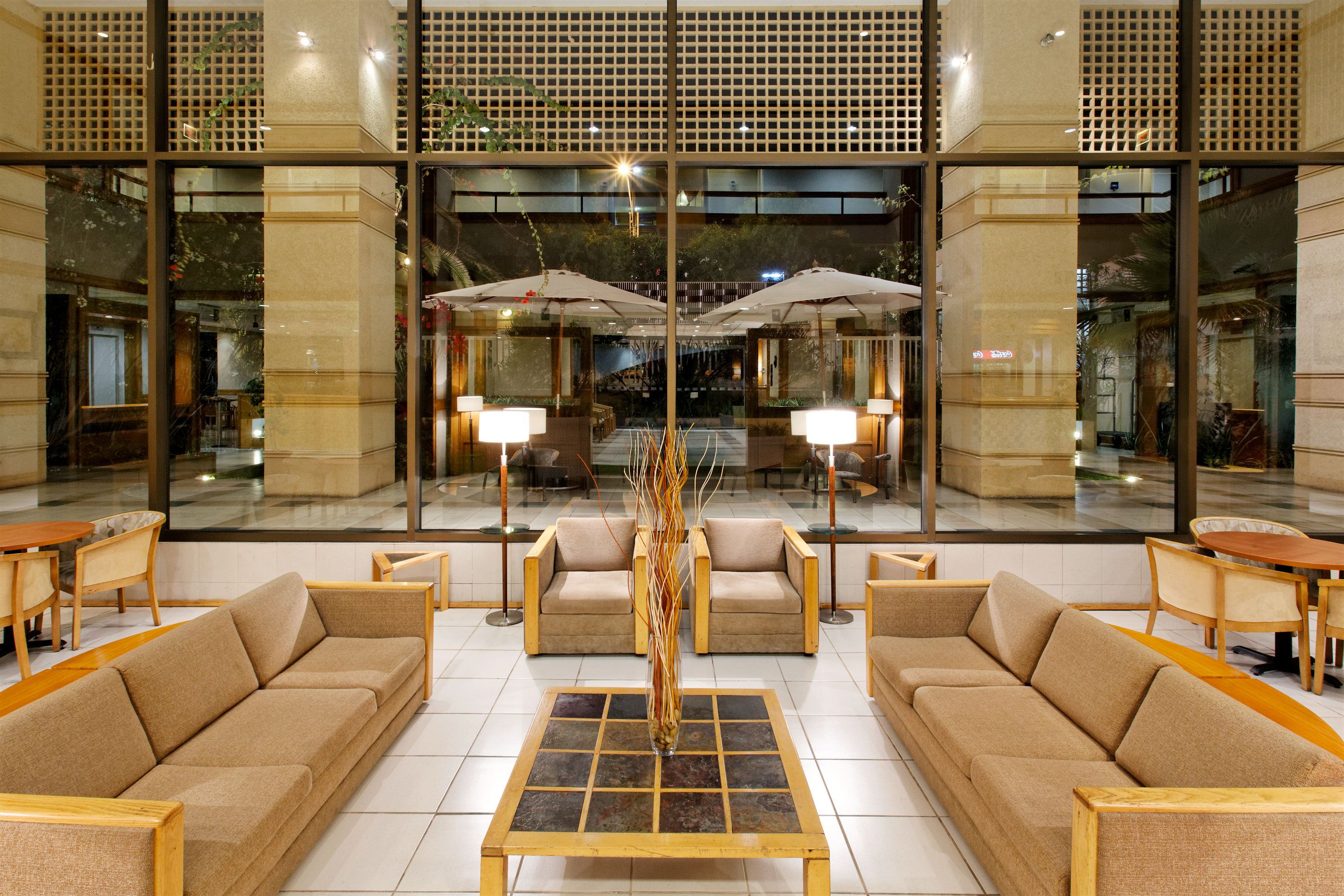 A lobby with sofas, a coffee table, and umbrellas.