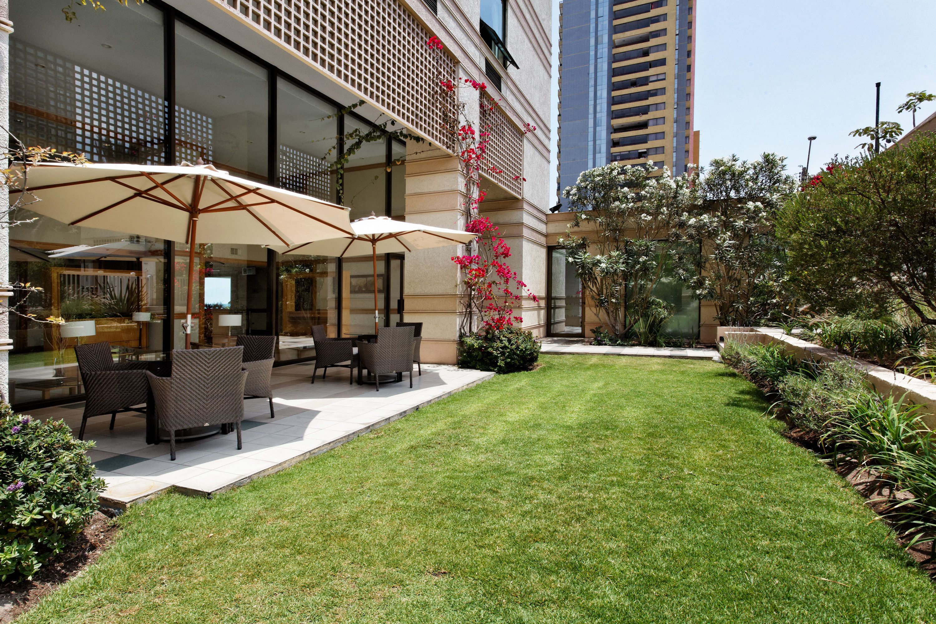 Un patio con mobiliario exterior y un césped cuidado.