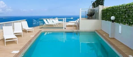 Piscine extérieure, parasols de plage, chaises longues