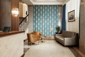 Welcome to our lobby, featuring a reception desk, staircase, and comfortable seating area.