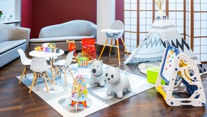 A children's play area with a round table, chairs, a play tent, and various toys. - Qubus Hotel Zielona Gora (Zielona Gora)