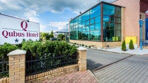 A hotel with a large sign reading "Qubus Hotel" and a modern glass building. - Qubus Hotel Zielona Gora (Zielona Gora)
