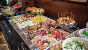 A buffet with various food items including meats, cheeses, and salads. - Polonia Hotel (Kraków)