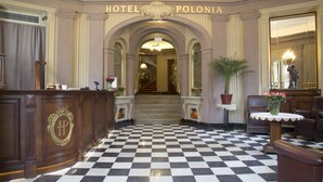 A checkered floor, a reception desk, and a staircase leading to the upper floors of Hotel Polonia. - Polonia Hotel (Kraków)