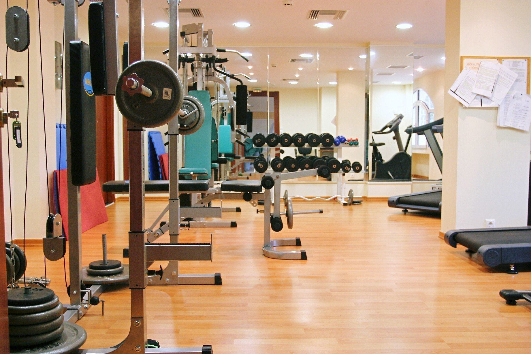 Un gimnasio con equipo de levantamiento de pesas, cintas de correr y máquinas de ejercicio.