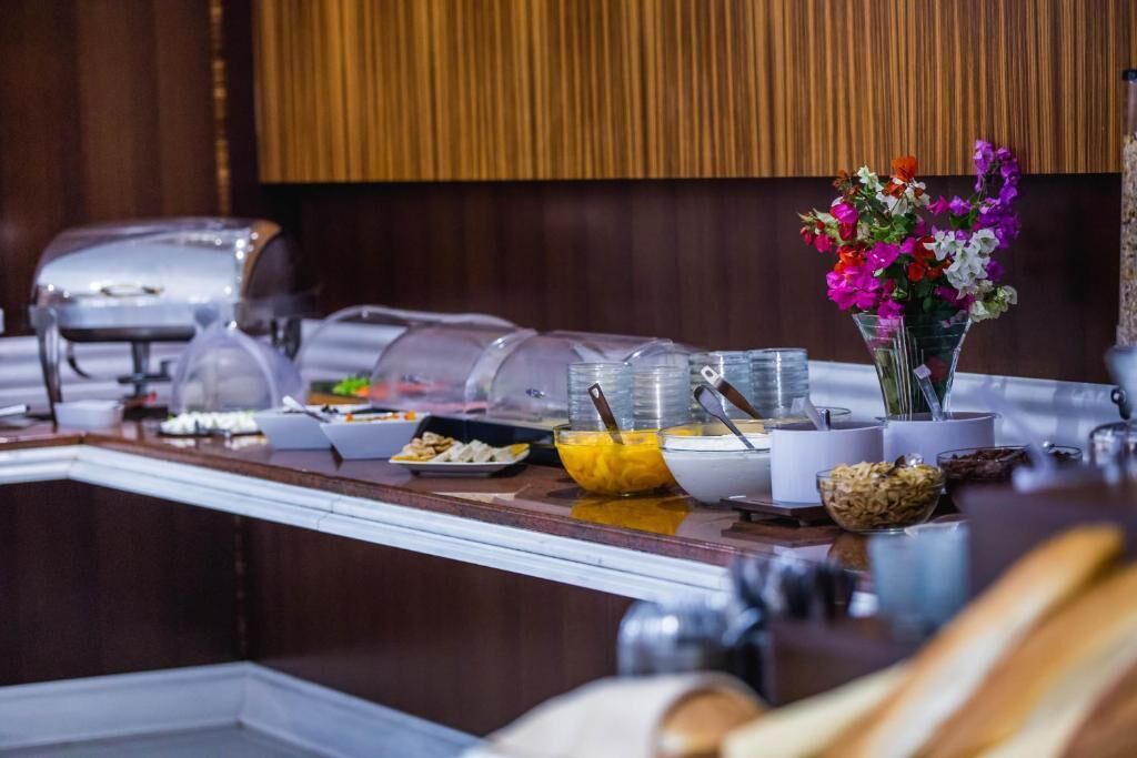 A buffet setup with various food items and a decorative vase of flowers.