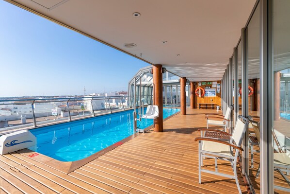 Una piscina techada, sillones reclinables de piscina